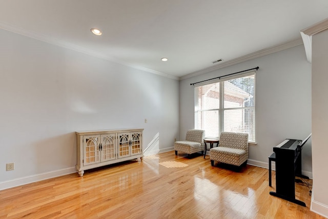 living area featuring light hardwood / wood-style flooring and ornamental molding