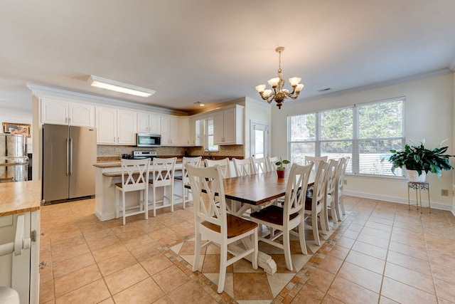 dining room with ornamental molding, light tile patterned floors, and an inviting chandelier