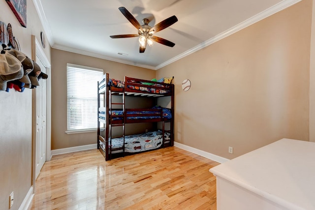 bedroom featuring ceiling fan, ornamental molding, and hardwood / wood-style floors