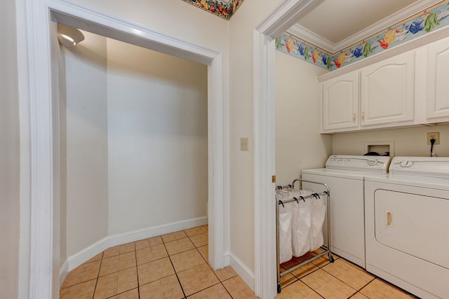 laundry area with cabinets, washing machine and clothes dryer, crown molding, and light tile patterned flooring