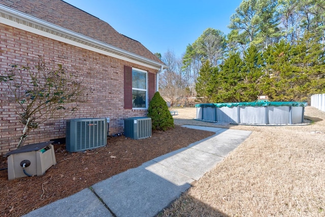 view of yard with a covered pool and central AC unit