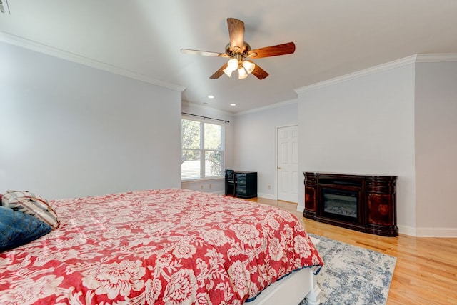 bedroom featuring wood-type flooring, ornamental molding, and ceiling fan