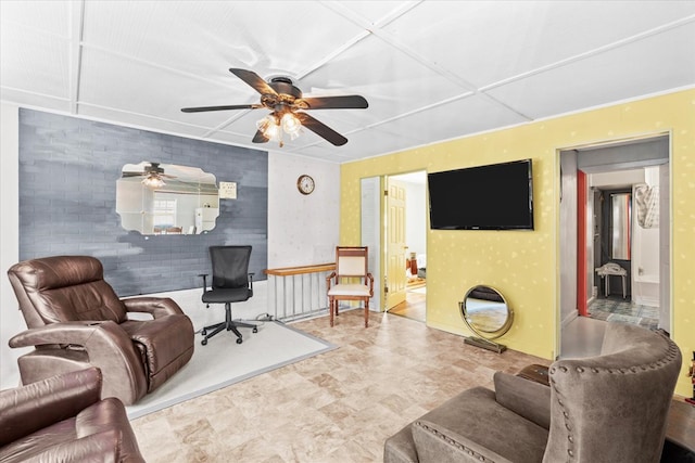 living room featuring ceiling fan and brick wall