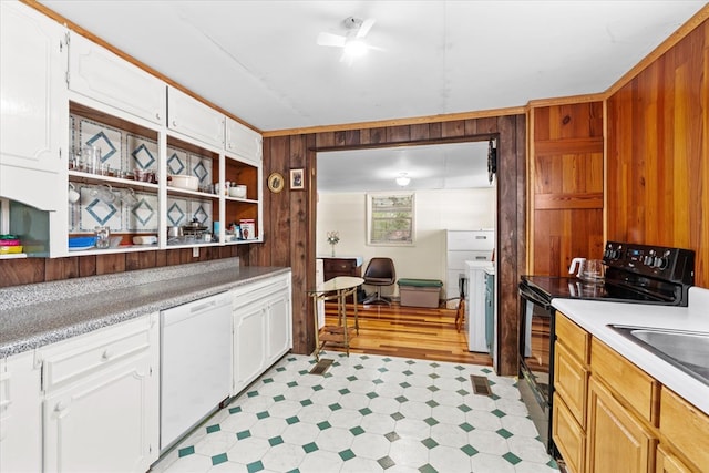 kitchen featuring black range with electric stovetop, wooden walls, white cabinets, and white dishwasher