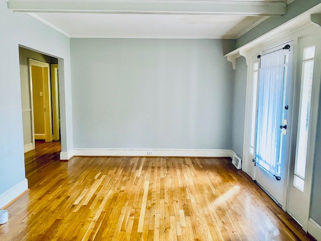 empty room featuring hardwood / wood-style floors and beam ceiling