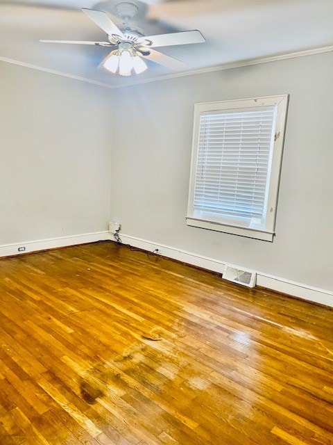 empty room featuring hardwood / wood-style flooring, ceiling fan, and ornamental molding