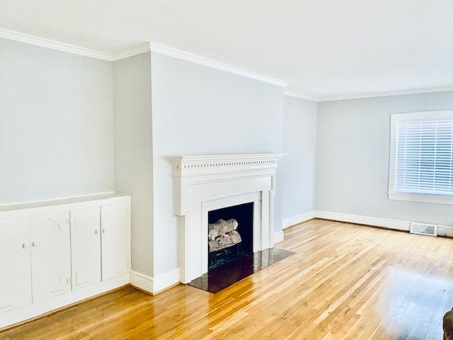 unfurnished living room with crown molding and wood-type flooring