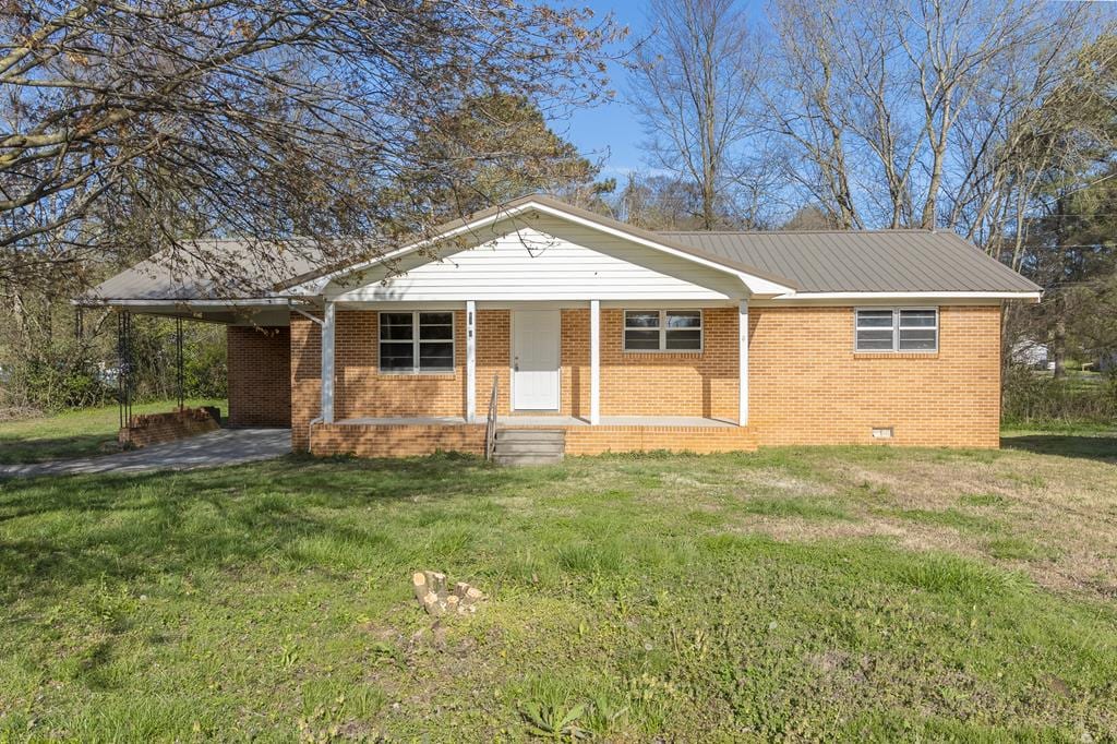 single story home featuring a carport and a front yard