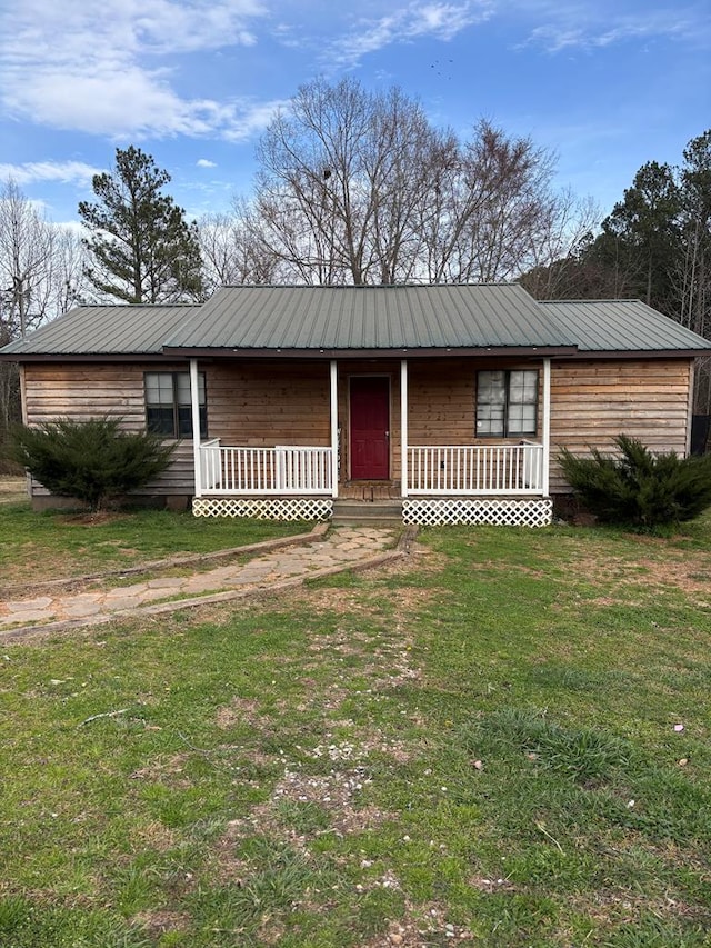 view of front of property featuring metal roof, a porch, and a front yard