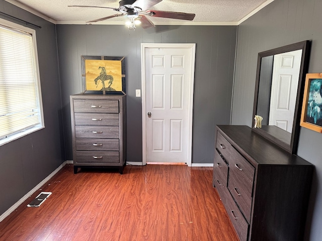 bedroom featuring dark wood-style flooring, visible vents, a textured ceiling, and baseboards