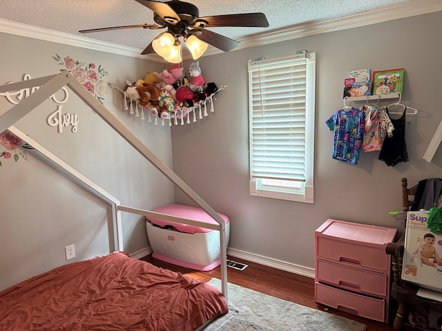 bedroom with a textured ceiling, wood finished floors, visible vents, a ceiling fan, and ornamental molding