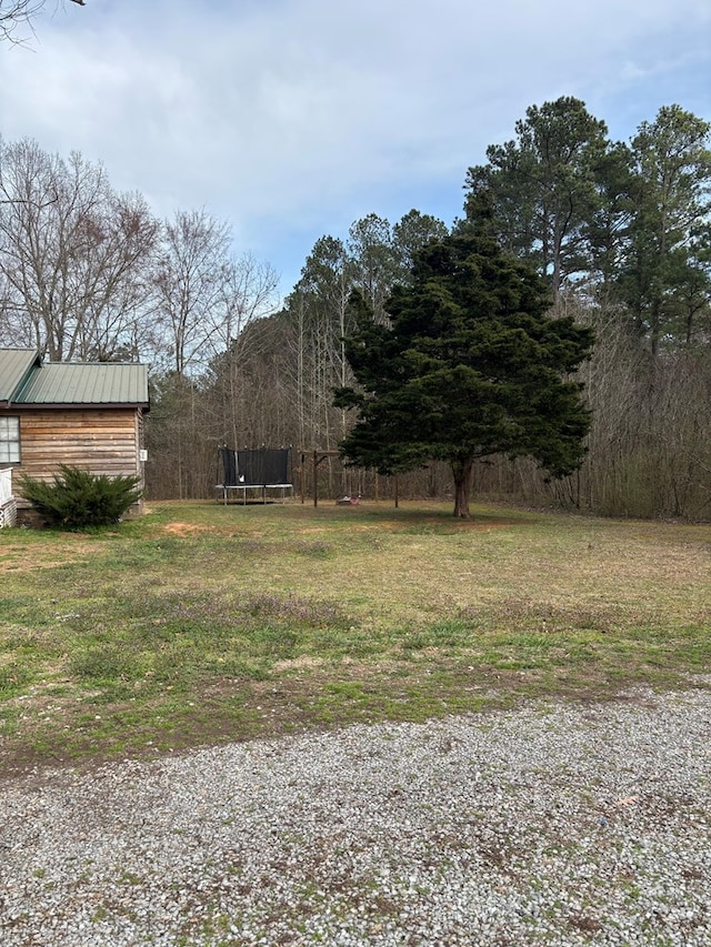 view of yard featuring a trampoline and fence