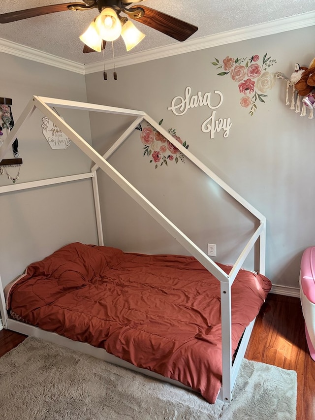 bedroom with ornamental molding, a ceiling fan, a textured ceiling, and wood finished floors