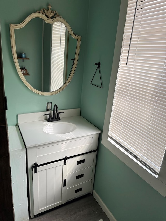 bathroom featuring vanity, baseboards, and wood finished floors