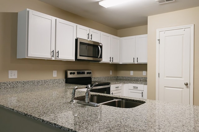 283 Parkland Way, Chatsworth, GA 30705 - kitchen with appliances with stainless steel finishes, light stone countertops, and white cabinets