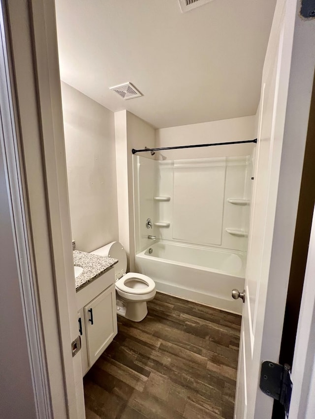 full bathroom with toilet, shower / bathtub combination, wood finished floors, vanity, and visible vents