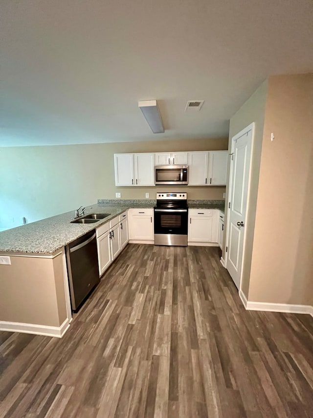 kitchen with visible vents, a sink, appliances with stainless steel finishes, and dark wood-style floors