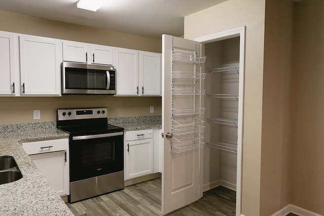 283 Parkland Way, Chatsworth, GA 30705 - kitchen with appliances with stainless steel finishes, light wood finished floors, white cabinets, and light stone countertops