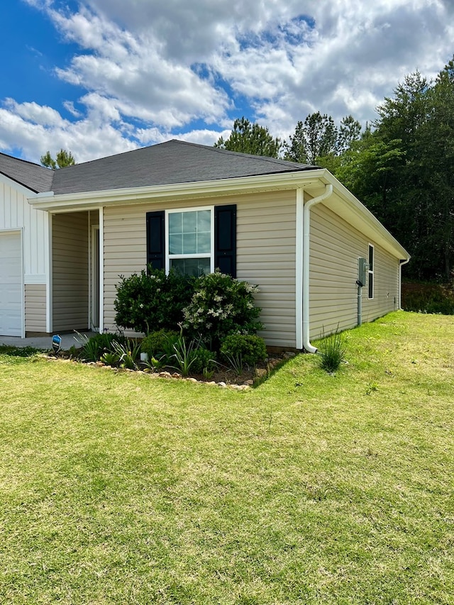 view of side of property featuring board and batten siding and a yard