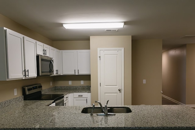 283 Parkland Way, Chatsworth, GA 30705 - kitchen featuring stainless steel appliances, a sink, stone countertops, and white cabinetry