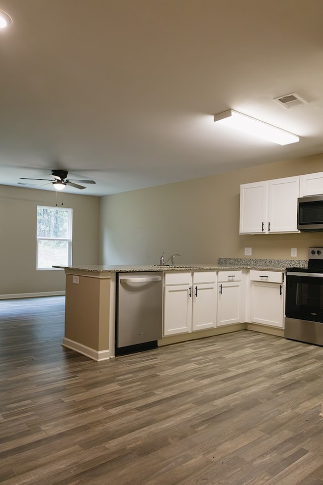 283 Parkland Way, Chatsworth, GA 30705 - kitchen with stainless steel appliances, wood finished floors, white cabinetry, a ceiling fan, and light stone countertops