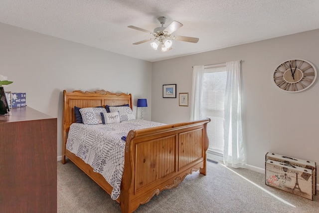 bedroom with ceiling fan, light colored carpet, and a textured ceiling