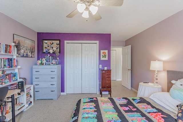 carpeted bedroom with ceiling fan, a closet, and a textured ceiling