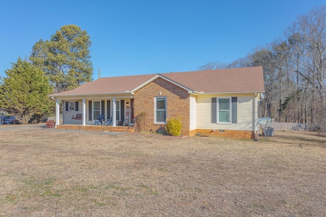 ranch-style home featuring covered porch and a front yard