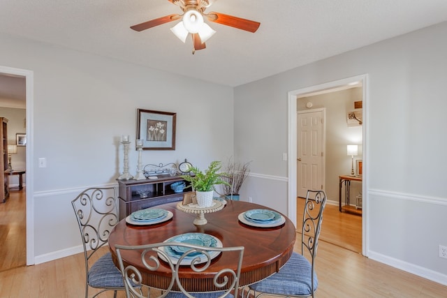 dining room featuring ceiling fan, a textured ceiling, and light hardwood / wood-style floors