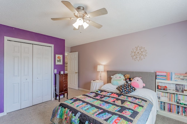 carpeted bedroom with ceiling fan, a closet, and a textured ceiling