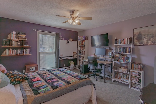 carpeted bedroom featuring ceiling fan and a textured ceiling