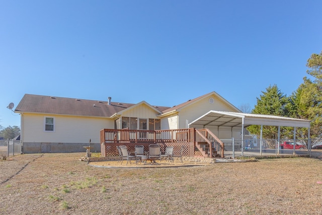 back of property with a yard, a carport, and a deck