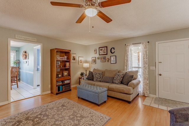 living room with light hardwood / wood-style flooring, a wealth of natural light, and a textured ceiling