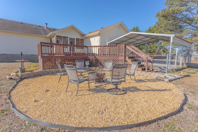 view of patio / terrace with a sunroom, a deck, and a fire pit