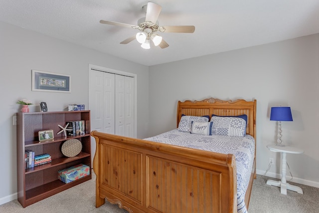 bedroom with light colored carpet, a textured ceiling, ceiling fan, and a closet