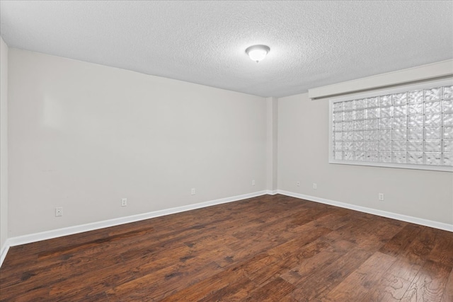 unfurnished room featuring dark hardwood / wood-style floors and a textured ceiling