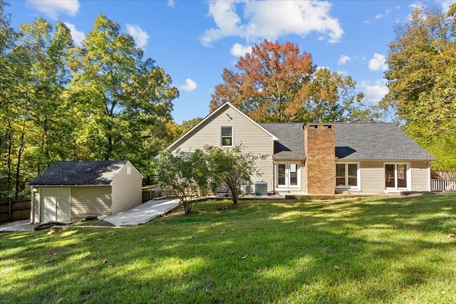 back of property with central AC unit, a lawn, a patio, and a storage shed