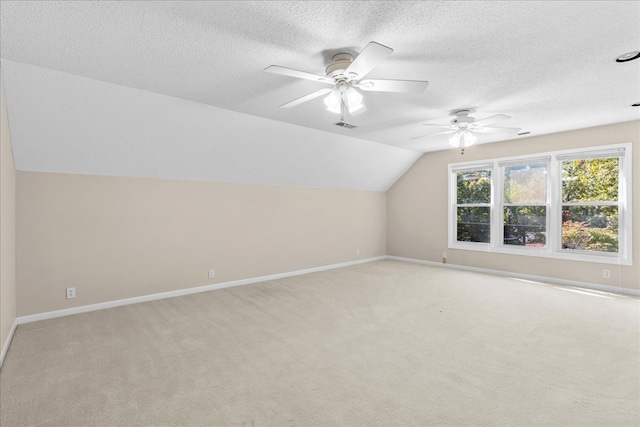 bonus room with vaulted ceiling, light carpet, ceiling fan, and a textured ceiling