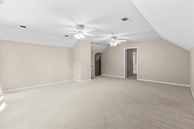 bonus room with vaulted ceiling, light colored carpet, ceiling fan, and a textured ceiling