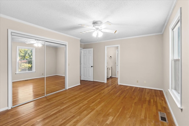 unfurnished bedroom with a closet, ornamental molding, and light hardwood / wood-style flooring