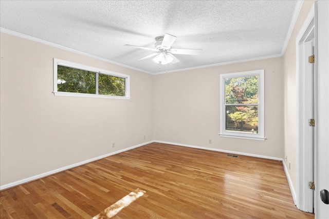 spare room featuring light hardwood / wood-style flooring, ornamental molding, ceiling fan, and plenty of natural light