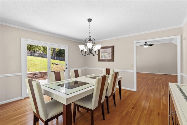 dining area featuring an inviting chandelier, ornamental molding, light hardwood / wood-style flooring, and a textured ceiling