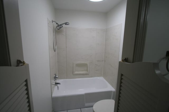 bathroom featuring tiled shower / bath and toilet