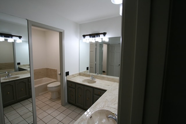 bathroom with vanity, toilet, tile patterned flooring, and a washtub