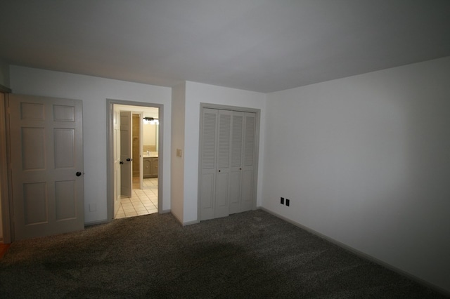 unfurnished bedroom with light colored carpet and a closet