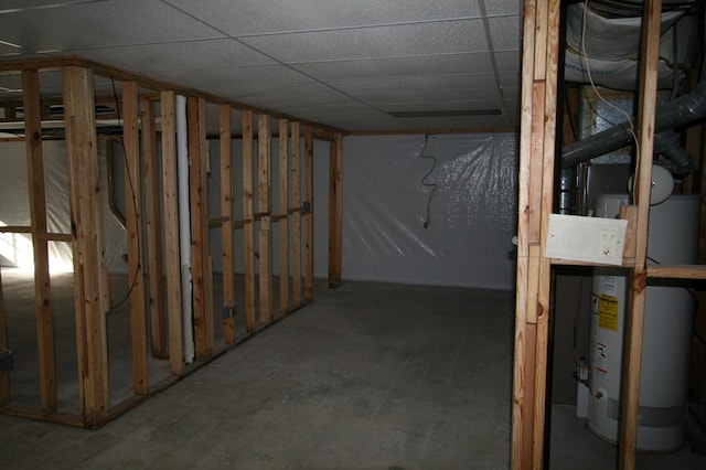 basement featuring water heater and a paneled ceiling