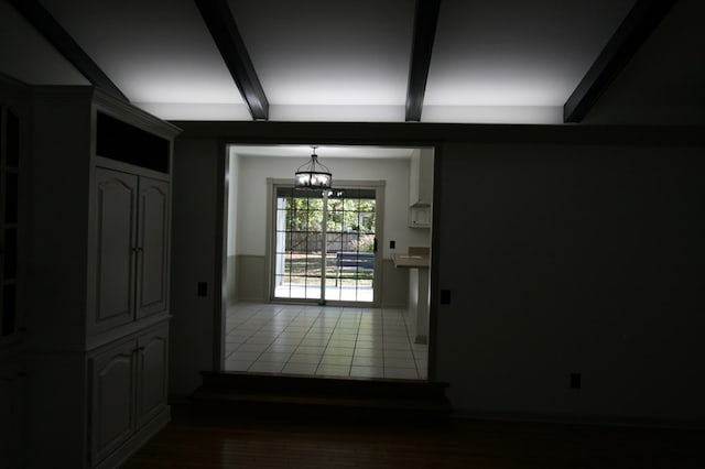 entryway with an inviting chandelier, tile patterned floors, and beam ceiling