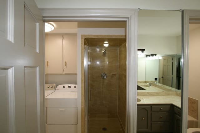 bathroom with vanity, separate washer and dryer, and a shower with door