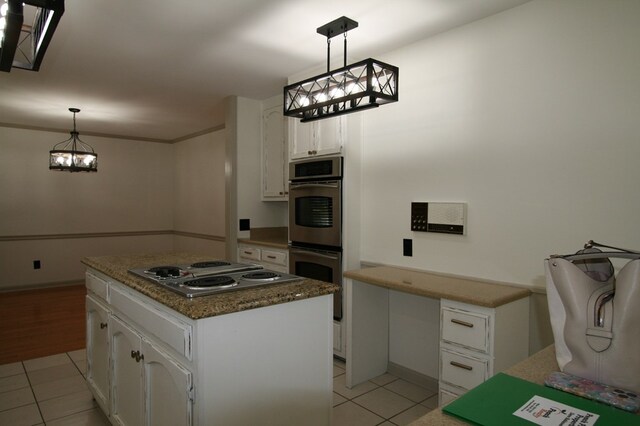 kitchen with a kitchen island, appliances with stainless steel finishes, hanging light fixtures, and white cabinets