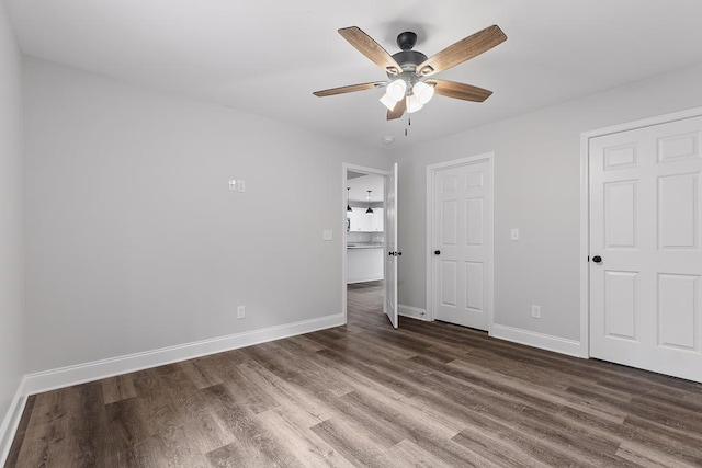 unfurnished bedroom with ceiling fan and dark hardwood / wood-style flooring